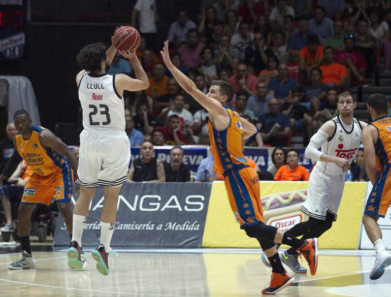 GRA595. VALENCIA, 09/06/2015.- El alero del Real Madrid, Sergio Llul (i), lanza un triple a falta de 1,8 segundos de la prórroga, consiguiendo la victoria ante el Valencia Basket durante el tercer partido de las semifinales disputado esta noche en el pabellón de la Fuente San Luis, en Valencia. EFE/Kai Försterling.