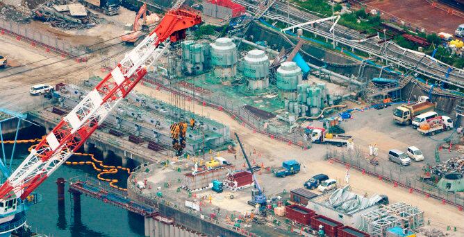 Una vista aérea muestra los trabajadores de la construcción de una barrera de tierra para detener el escape de agua radiactiva en el mar en la central de Fukushima