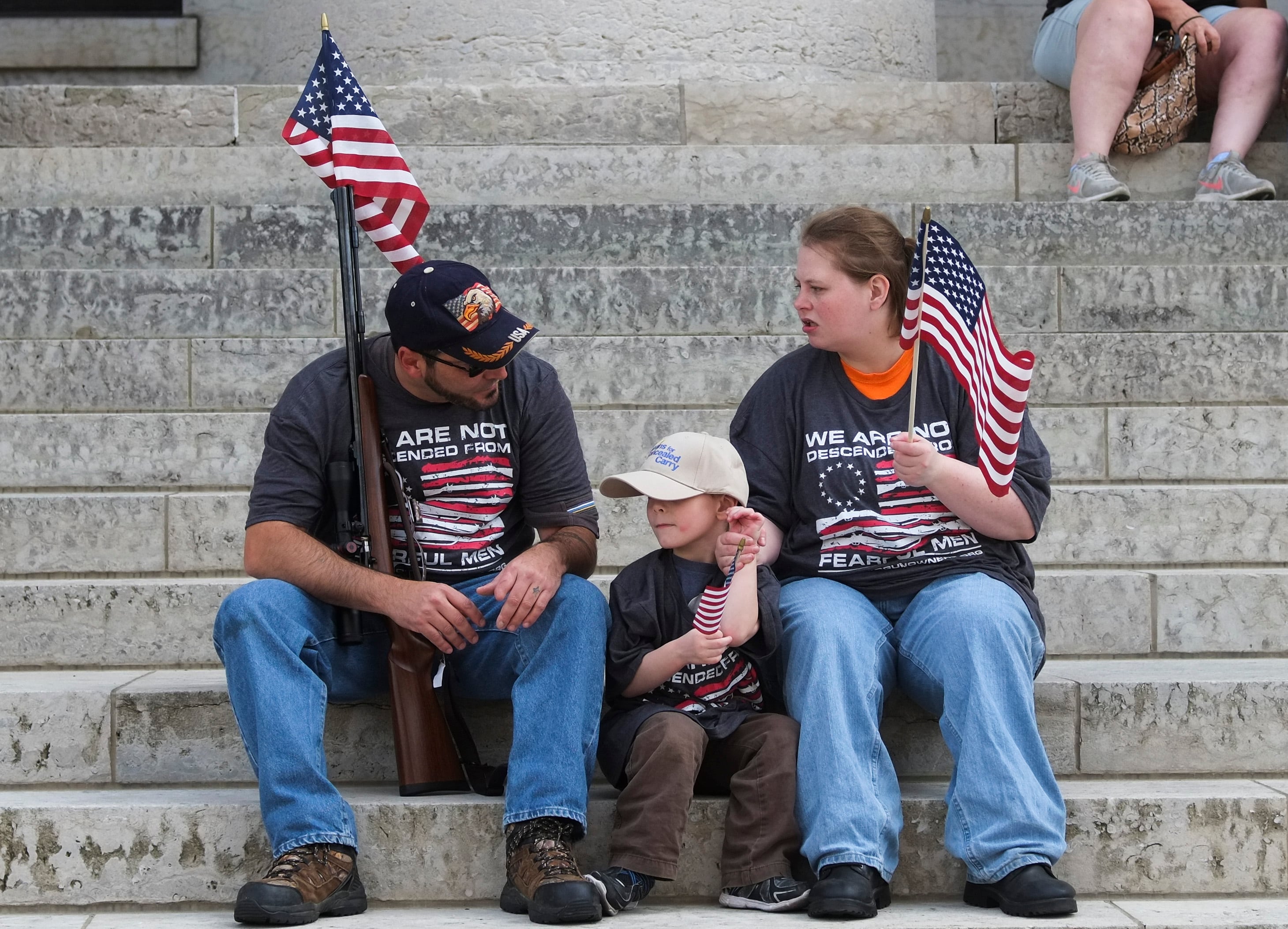 Dos personas y un niño protestan en Ohio, EEUU, para defender el derecho a portar armas en el país