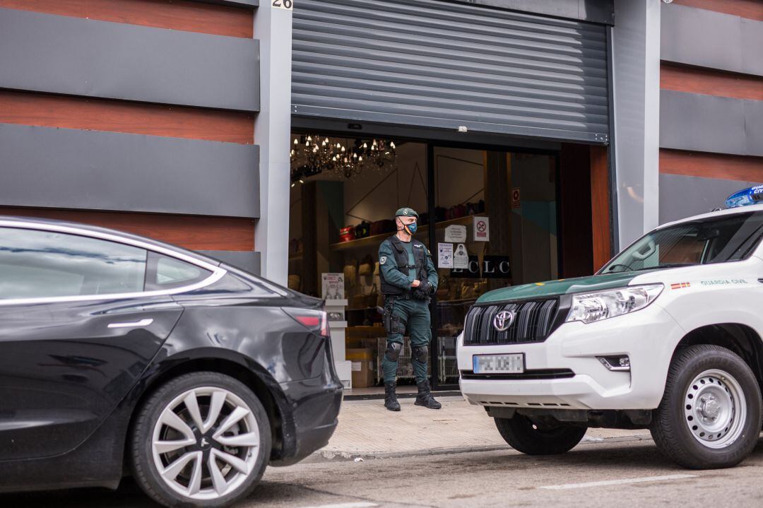 Un agente de la Unidad Central Operativa de la Guardia Civil (UCO) vigila en uno de los registros realizados a establecimientos del polígono industrial de Cobo Calleja.