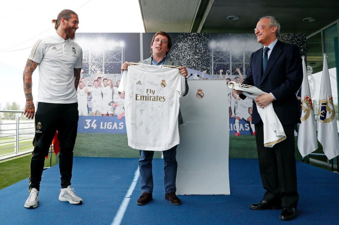 Almeida posa con la camiseta firmada por la plantilla madridista.