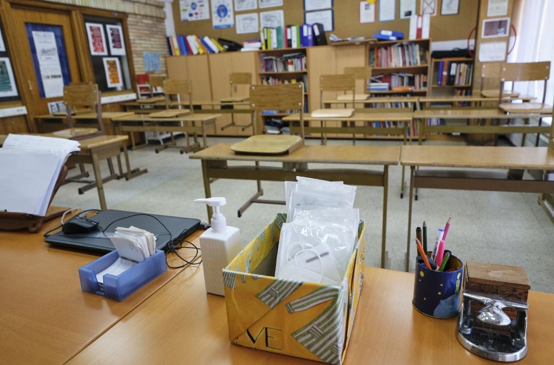 Mascarillas y gel desinfectante en la mesa del profesor de un aula.