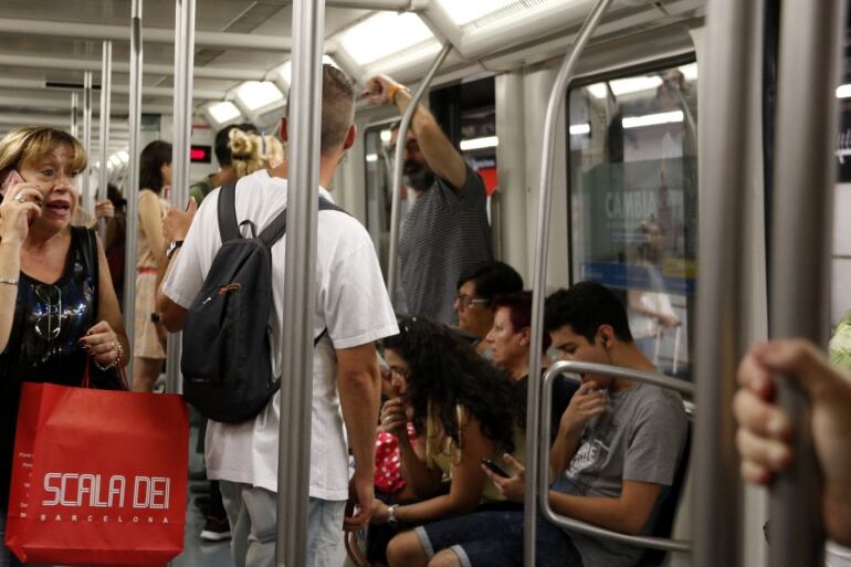 Un agent de paisà dels Mossos d'Esquadra vigila que no es produeixi cap furt a l'interior d'un vagó de metro.