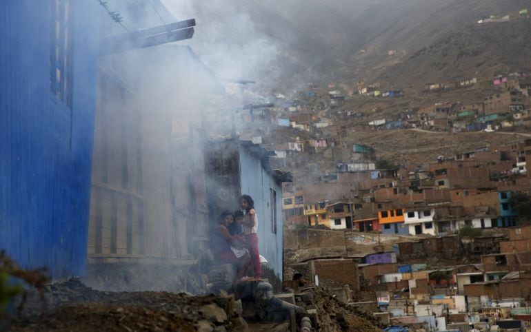 Residentes esperan fuera de su casa mientras es fumigada contra el virus del zika en Lima, Perú