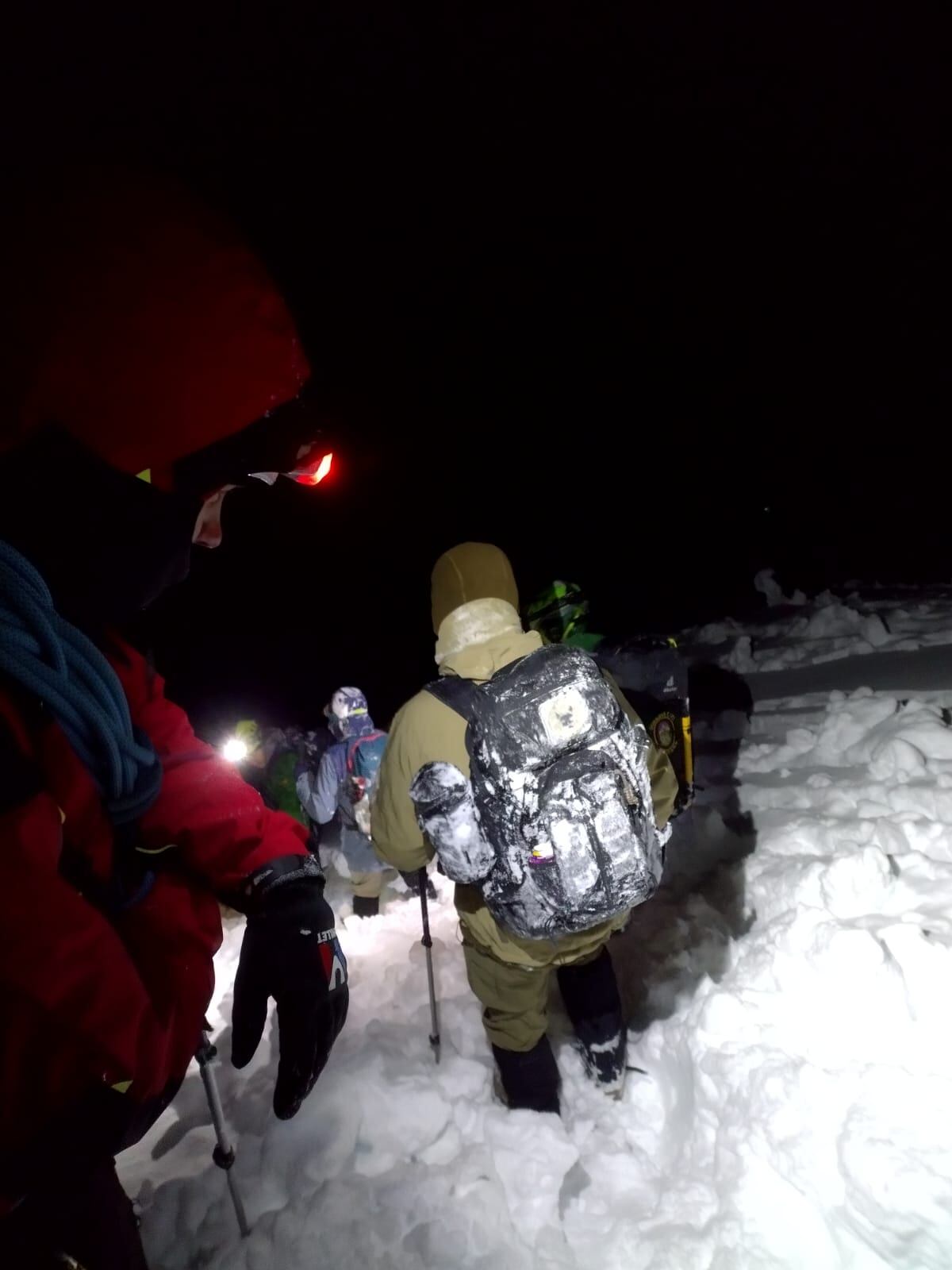 La pareja rescatada avanza acompañada de los equipos de rescate.