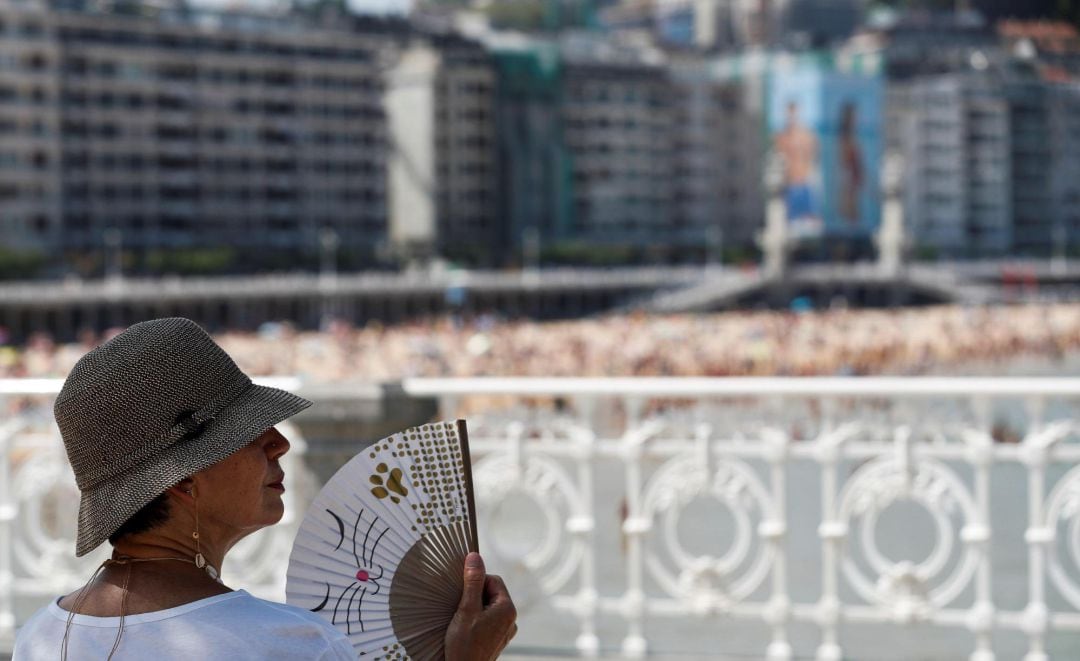 Una mujer combate el calor con su abanico junto a la playa de La Concha de San Sebastián