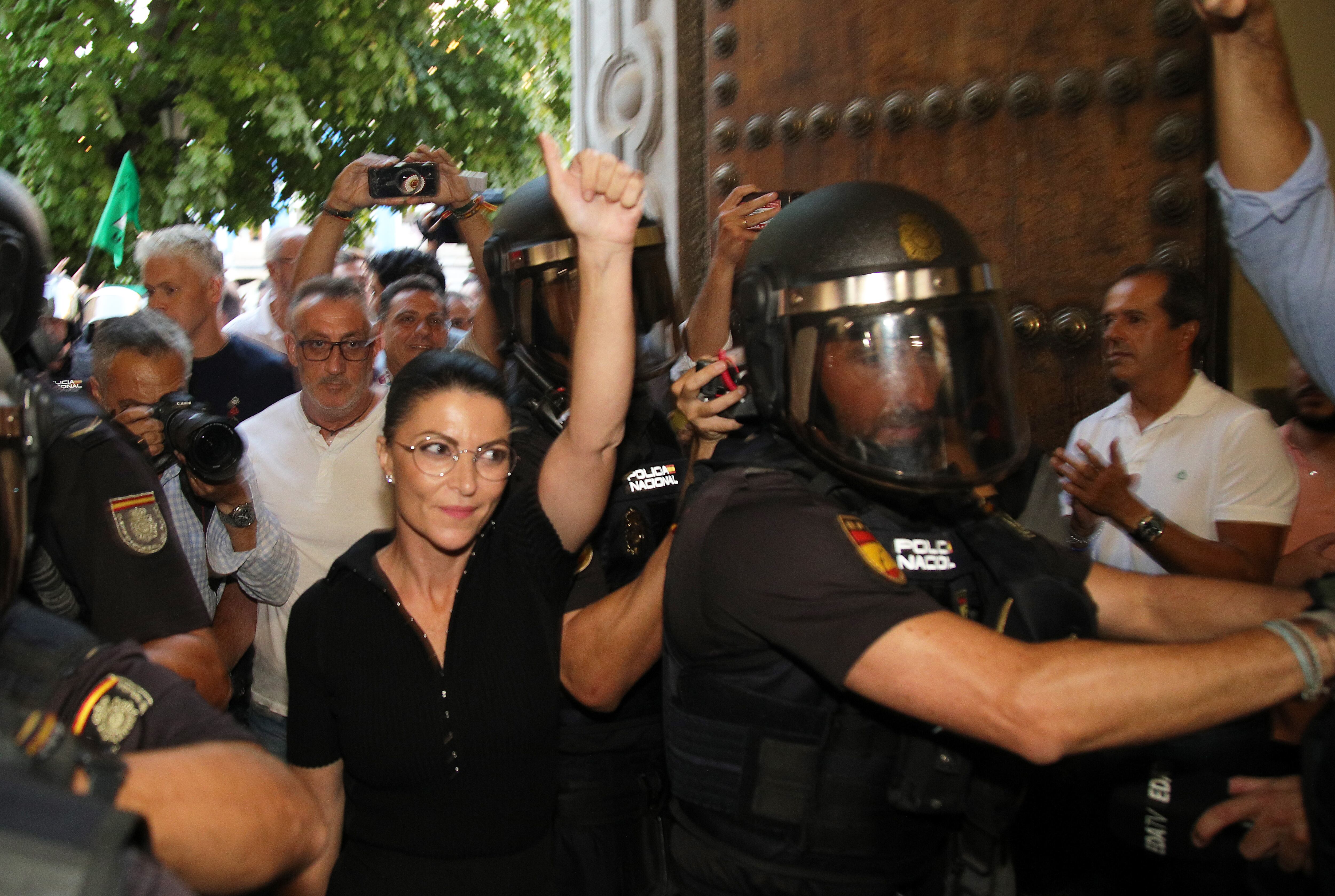 GRANADA, 15/09/2022.- La ex política Macarena Olona (c) intenta acceder a un acto en la facultad de Derecho de Granada este jueves. Varios centenares de personas se han concentrado este jueves en la Facultad de Derecho de Granada para intentar impedir la conferencia de la que fuera candidata de Vox a la Junta, Macarena Olona, esta tarde en la universidad. EFE/ Pepe Torres
