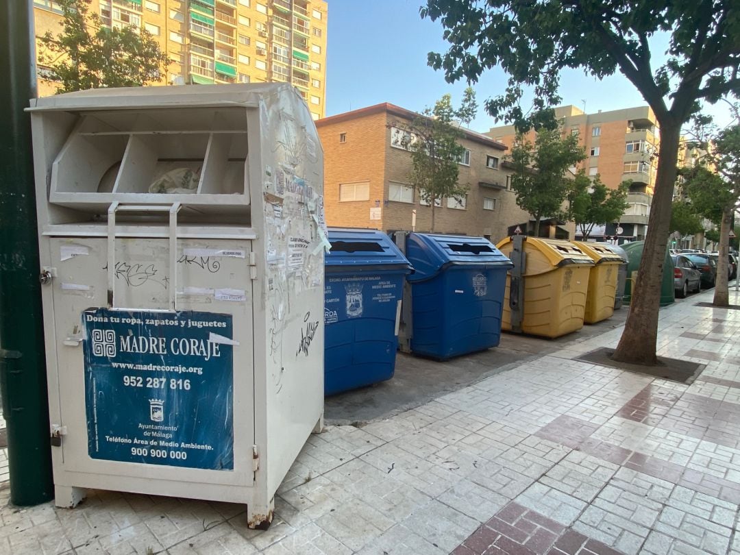 Uno de los contenedores (en blanco) para donar ropa en Málaga