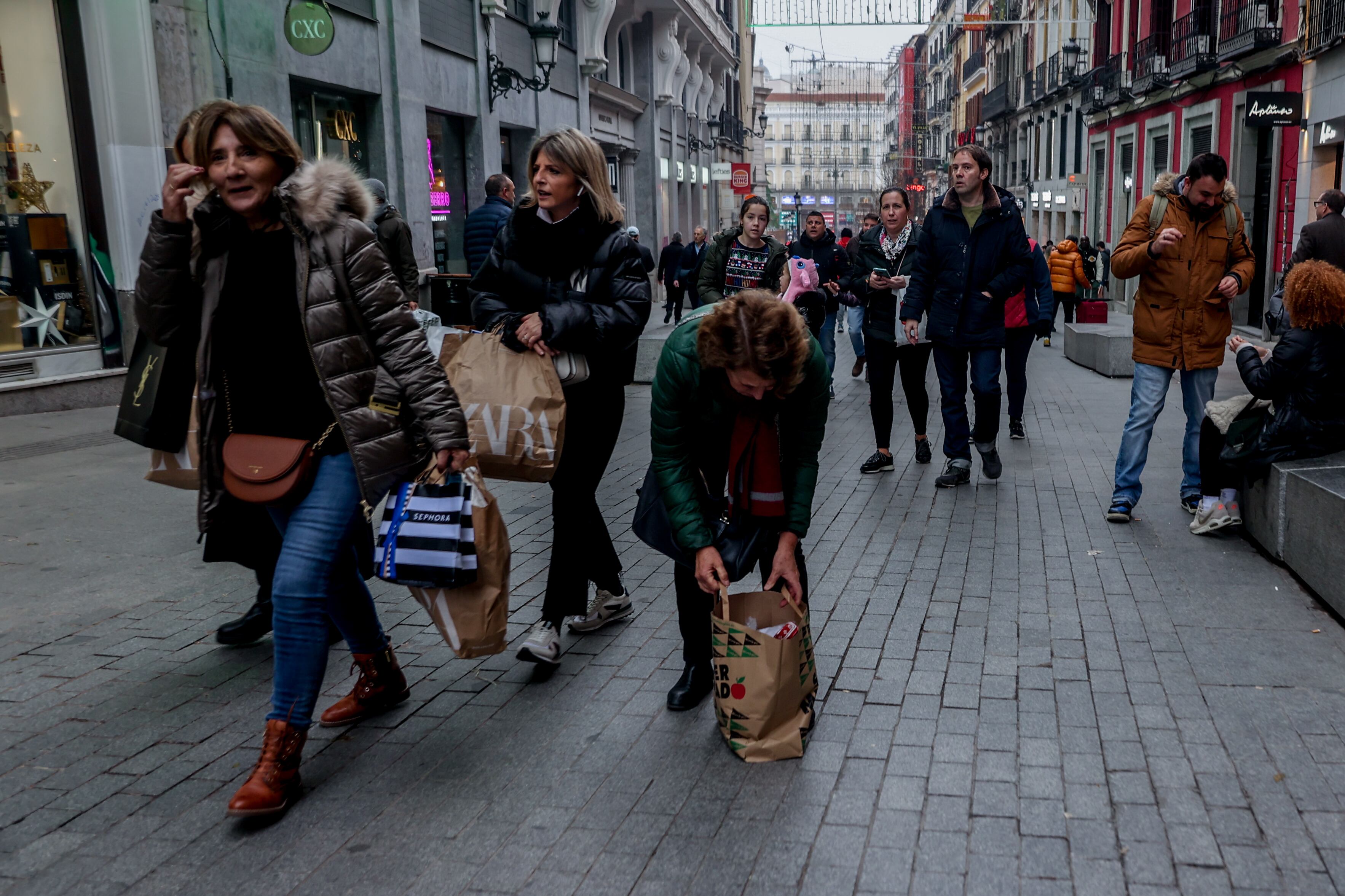 MADRID, SPAIN - JANUARY 07: Several people walk with sales bags in Preciados street.