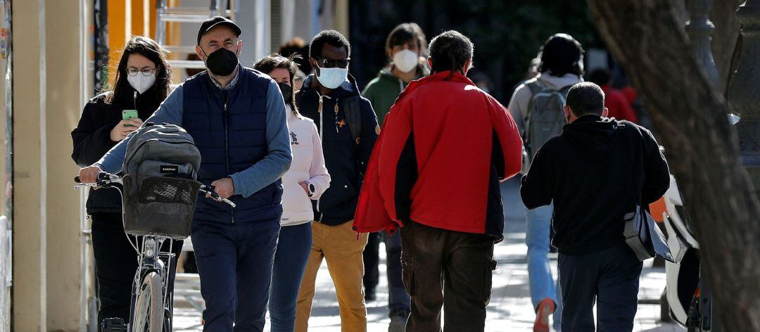 Varias personas protegidas con mascarillas por la ciudad 