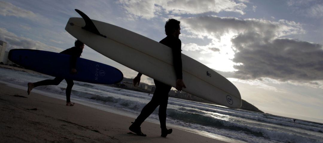 Dos surfistas entran al agua en la playa del Orzán de A Coruña