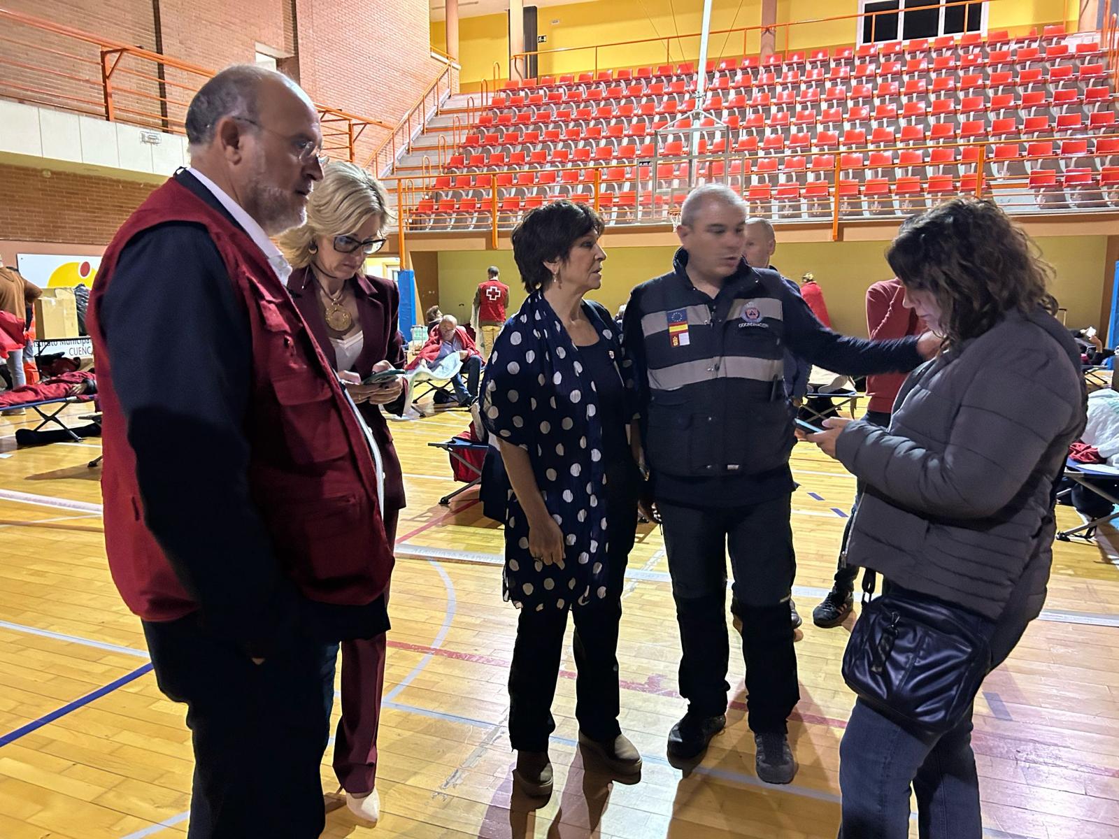 A la izquierda, José Luis Martínez Guijarro (vicepresidente primero del Gobierno de Castilla-La Mancha) y María Ángeles López (delegada de la Junta en Cuenca), junto a otros técnicos del dispositivo de apoyo a los viajeros en el polideportivo San Fernando de Cuenca.