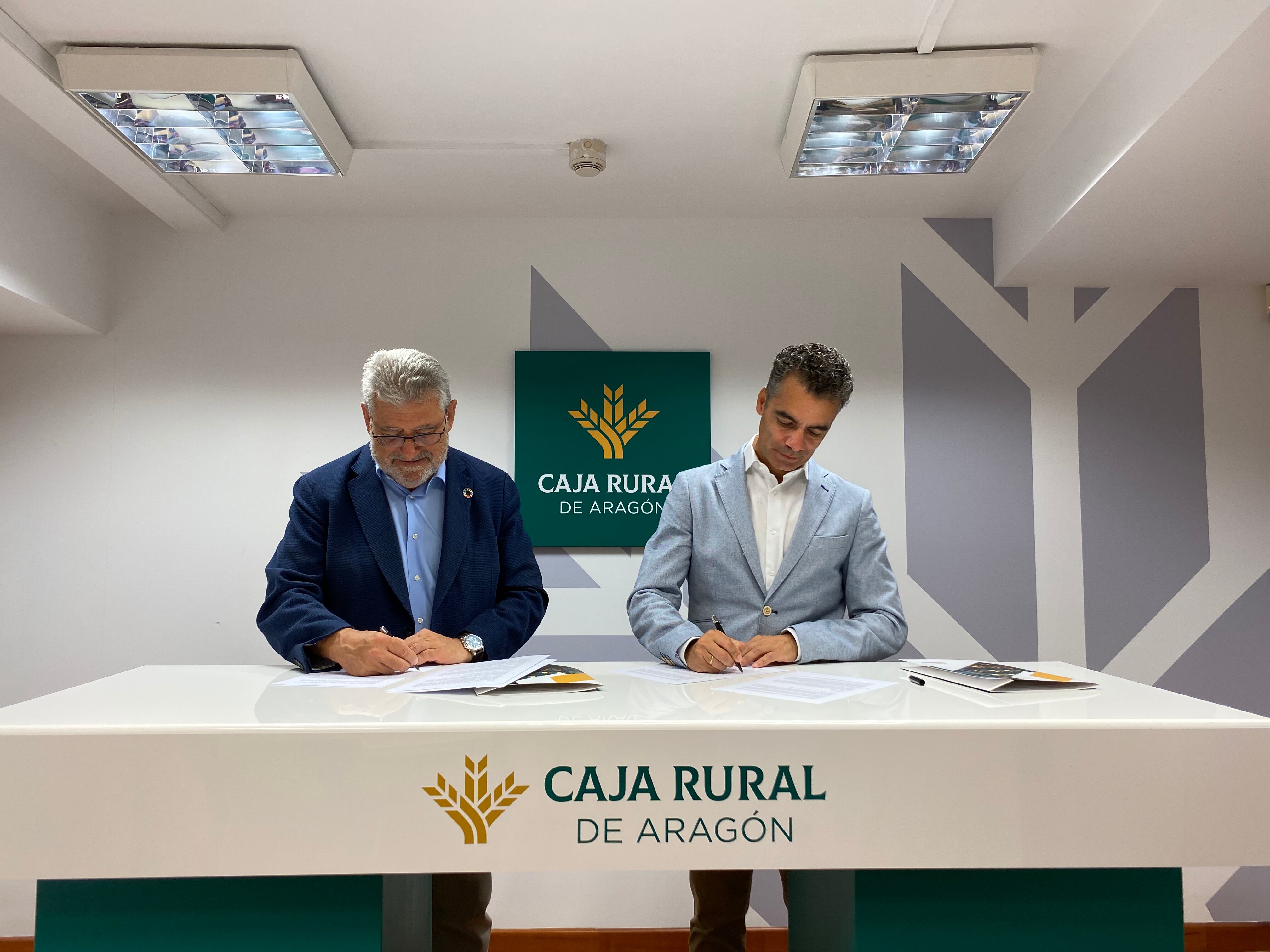 El rector de la Universidad de Zaragoza, José Antonio Mayoral (izquierda) firma el convenio con el director general de Caja Rural, Luis Ignacio Lucas. / Caja Rural