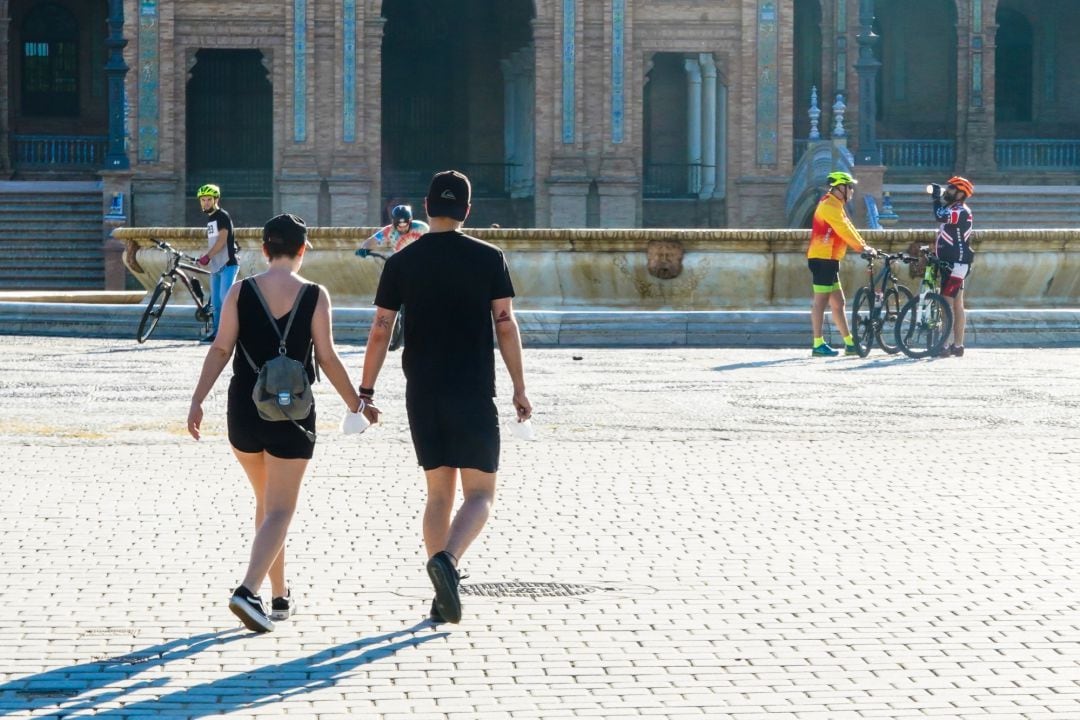 Una pareja cogidos de la mano  en  la Plaza de España, en Sevilla 