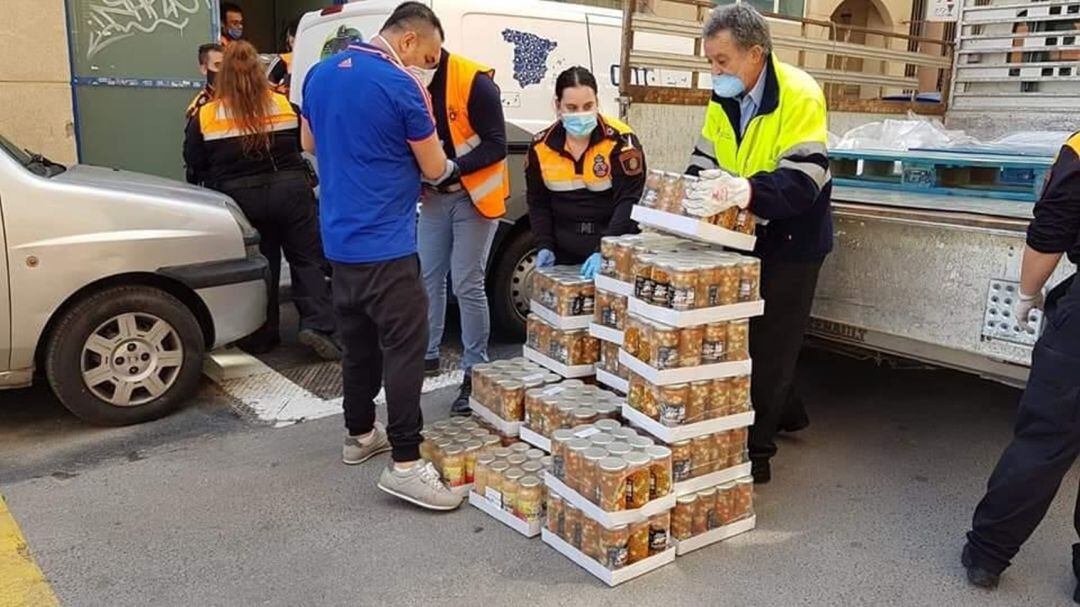 Efectivos de Protección Civil descargan parte de los lotes de alimentos que en cinco días el Ayuntamiento ha distribuido en familias vulnerables.