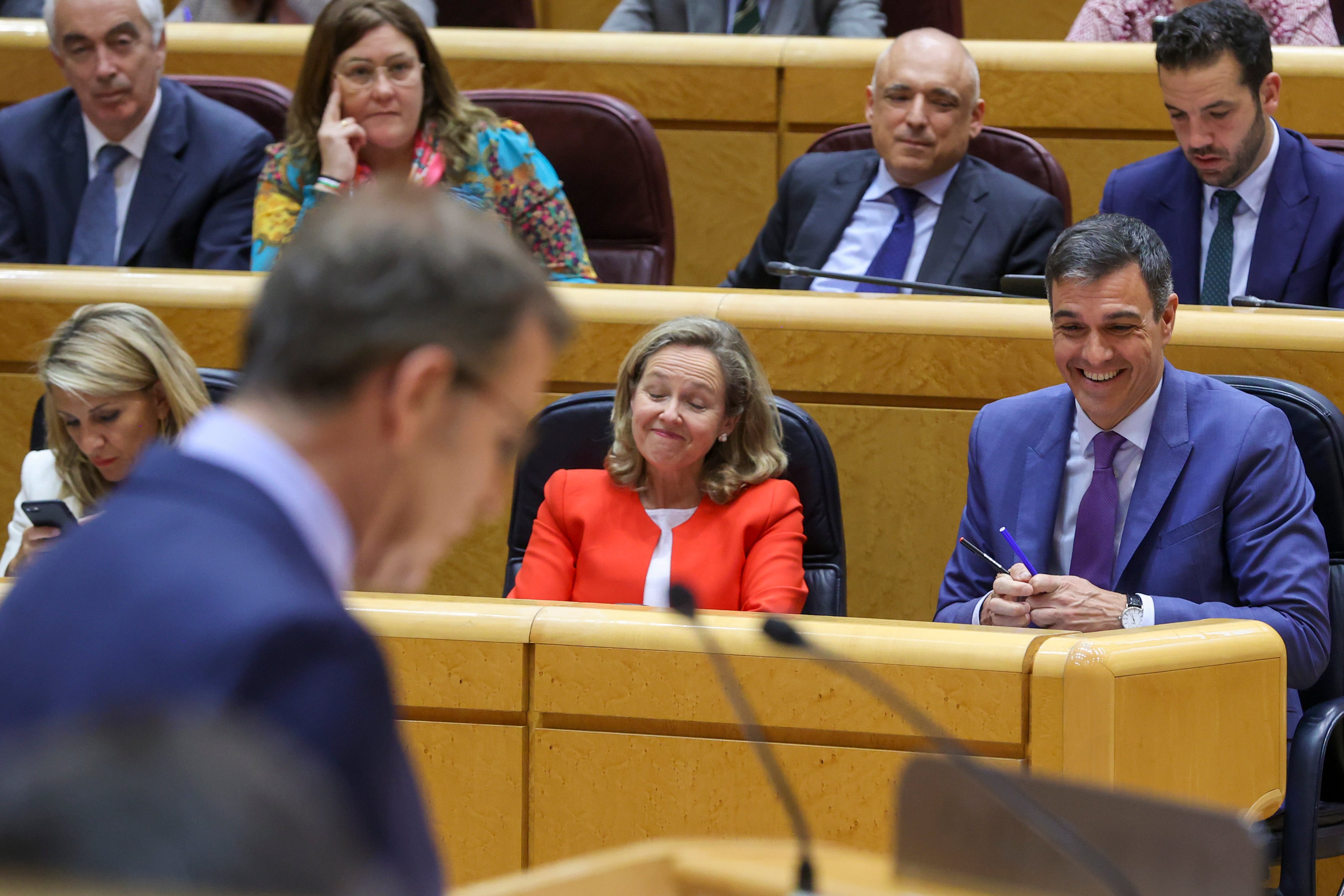 El presidente del Gobierno, Pedro Sánchez (d), reacciona durante la intervención del líder del PP, Alberto Núñez Feijóo, en el pleno del Senado este martes en Madrid.