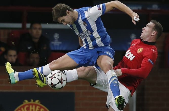 Martínez pugna acrobáticamente un balón con Rooney.