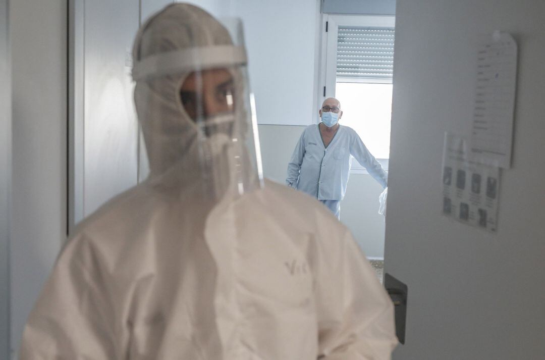 Trabajadores sanitarios entran en la habitación de un paciente negativo de Covid-19 en el Hospital Arnau de Vilanova, en València