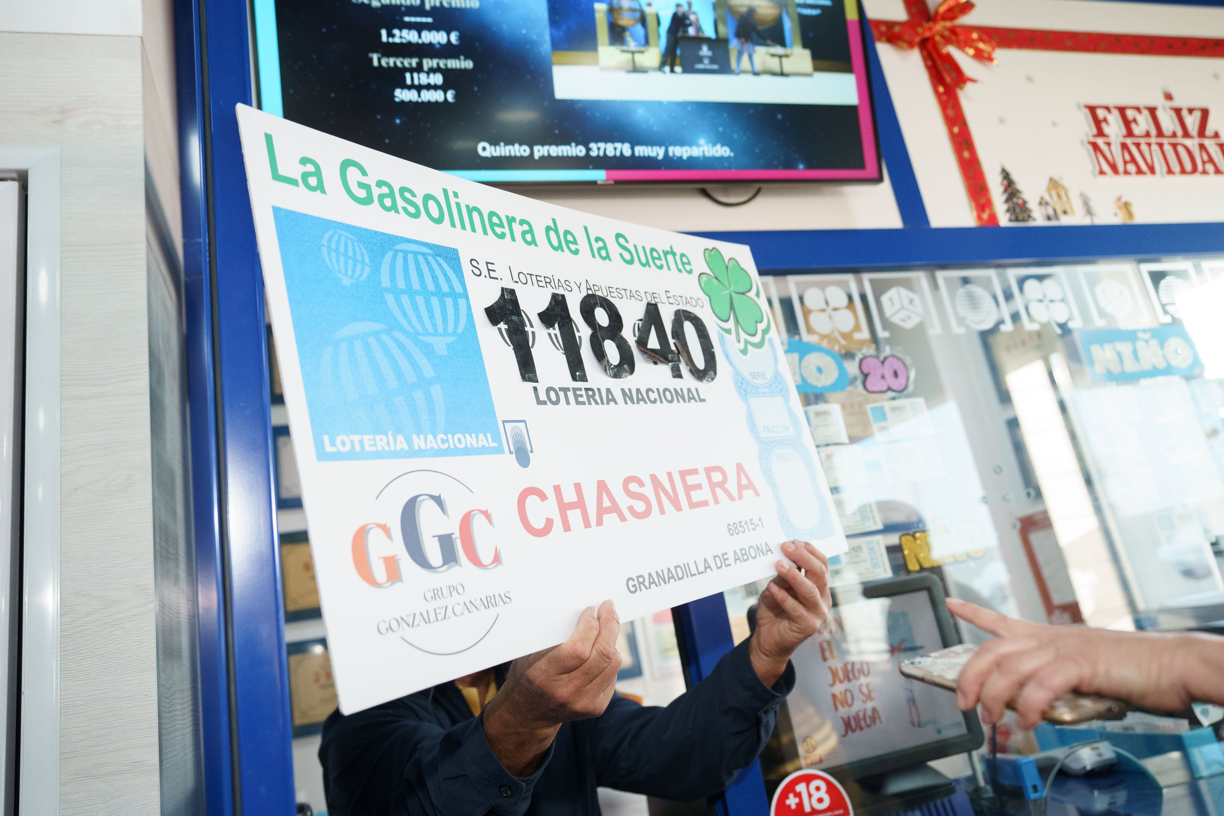 Propietarios y empleados de la gasolinera La Chasnera en el km 54 de la autopista TF-1, en el municipio de Granadilla de Abona en Tenerife, celebran el segundo premio del sorteo extraordinario de Navidad de la Lotería Nacional que recayó en el número 11840. EFE/Ramón de la Rocha