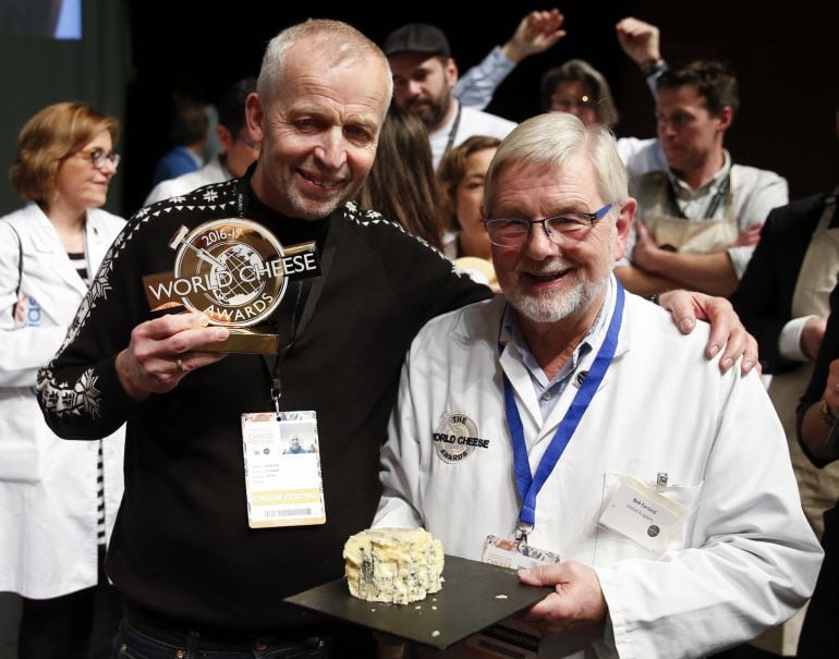 El noruego Gunnar Waager (i) posa junto a un miembro del jurado tras recibir el galardón al mejor queso del mundo.