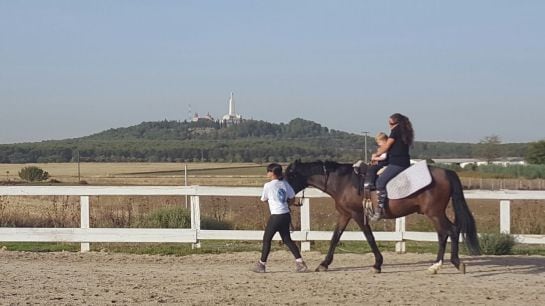 Daniela hace ejercicios de psicomotricidad sobre el caballo