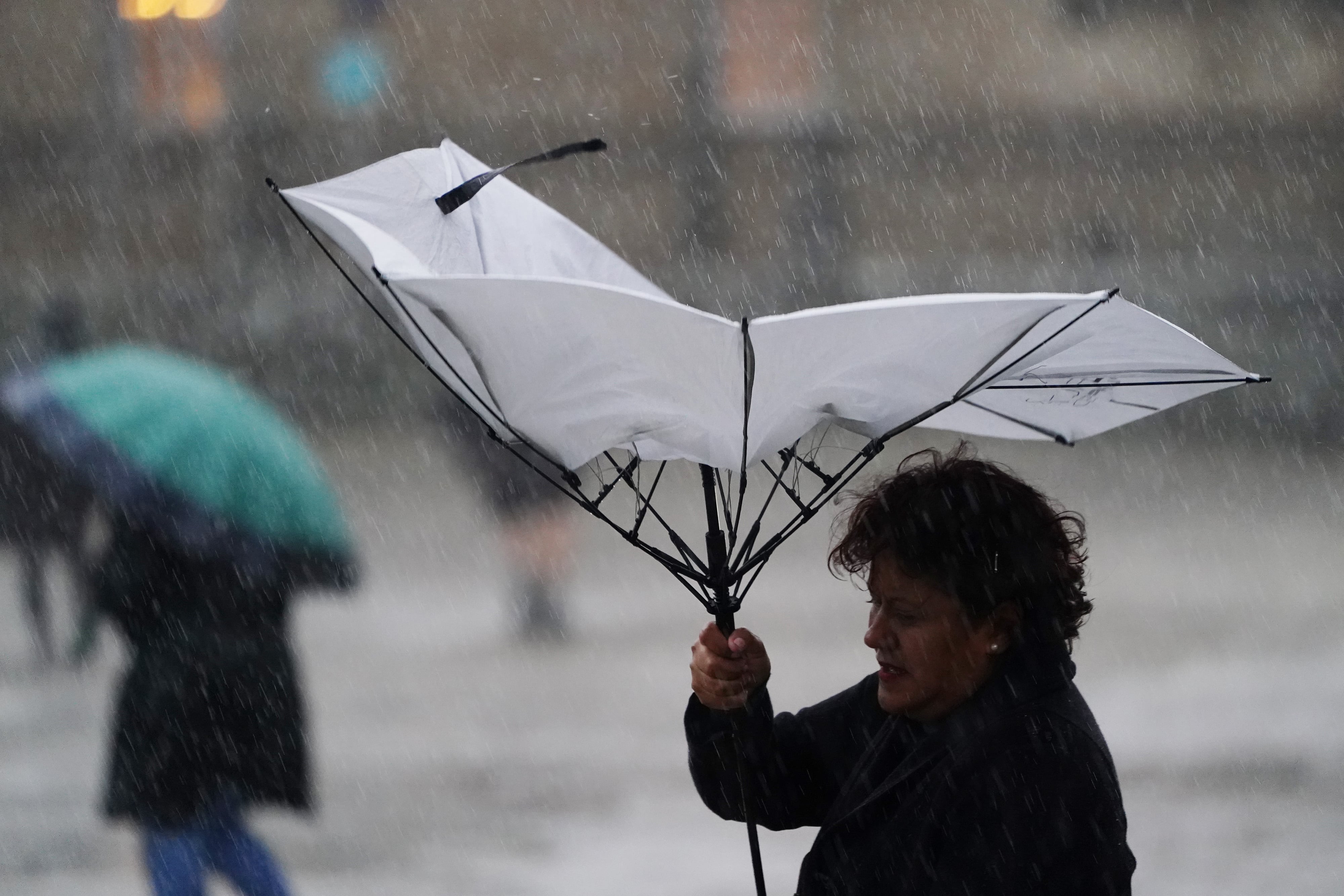 SANTIAGO DE COMPOSTELA, A CORUÑA, SPAIN - OCTOBER 19: A woman holds an umbrella during the passage of squall 'Aline' on October 19, 2023, in Santiago de Compostela, A Coruña, Galicia, Spain. Squall Aline, the first squall considered to have an impact this season, has made its presence felt in Santiago de Compostela. Intense rainfall has left between 25 and 30 liters of water per square meter. The heavy rainfall, wind and waves have left incidents in several areas of the community, such as falling trees and occasional flooding. The storm has caused in Galicia more than 260 incidents recorded by 112 since noon yesterday, Wednesday, October 18, until the early hours of this morning. (Photo By Alvaro Ballesteros/Europa Press via Getty Images)