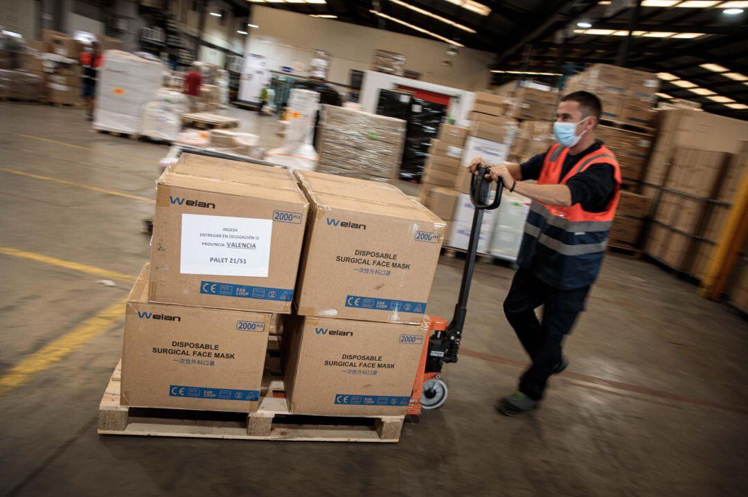Un operario transporta mascarillas que el Gobierno ha enviado a València para distribuir entre entidades locales y familias más necesitadas en el inicio del curso escolar
