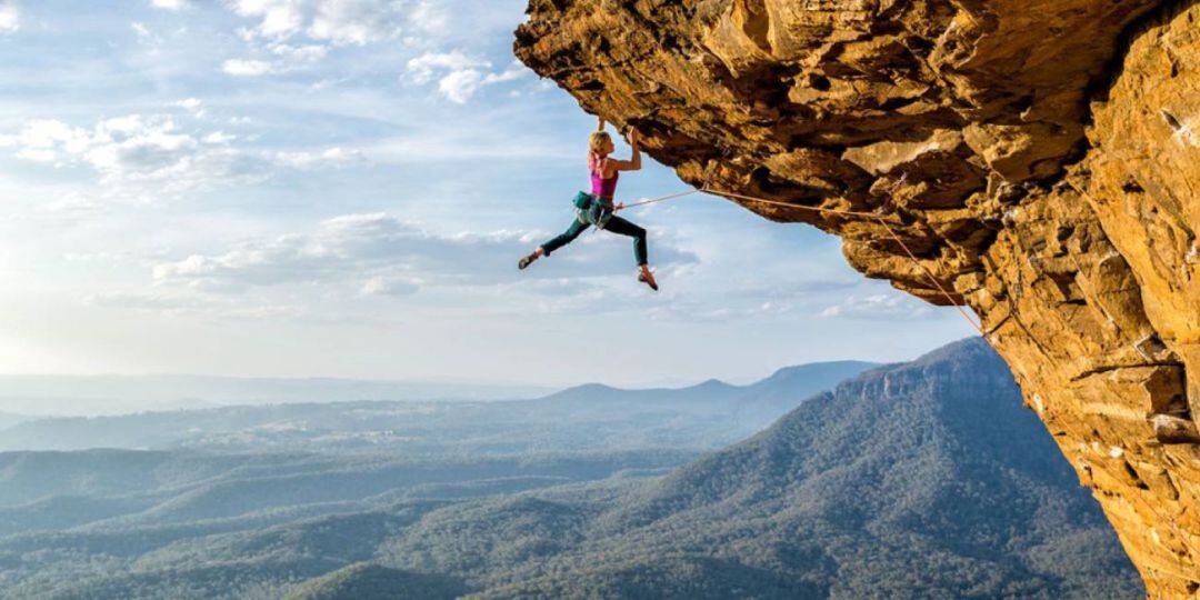 Una mujer practica escalada en una montaña rocosa