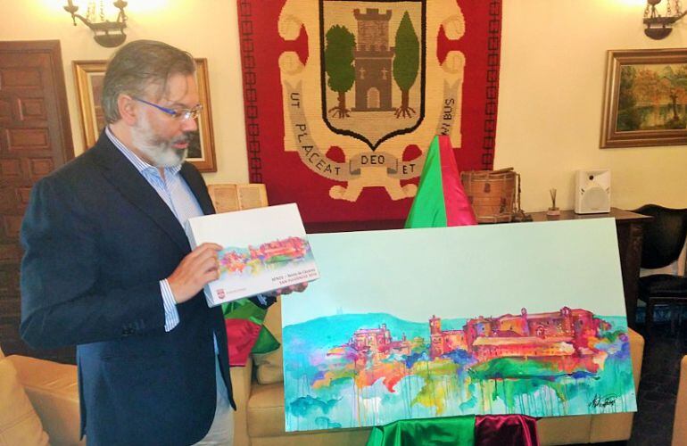 Fernando Pizarro, sostiene el lienzo que se entregará a los ganadores del premio San Fulgencio ante la obra original