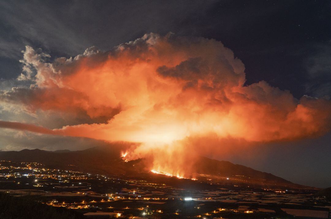 La luna llena ilumina la nube producida por el volcán de La Palma.