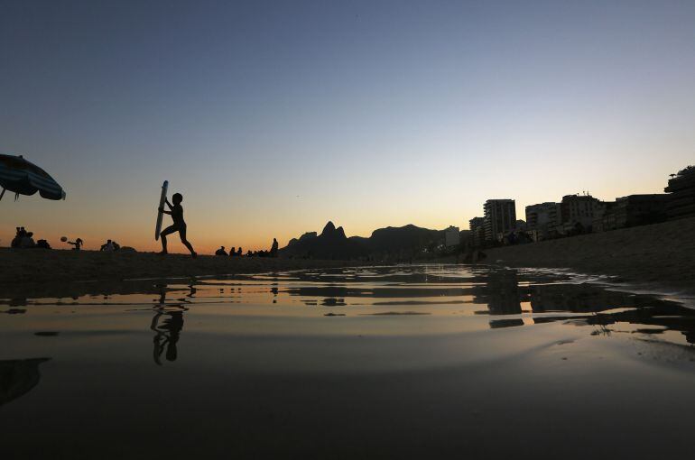 Un grupo de niños se baña en un río a su paso por una ciudad. 