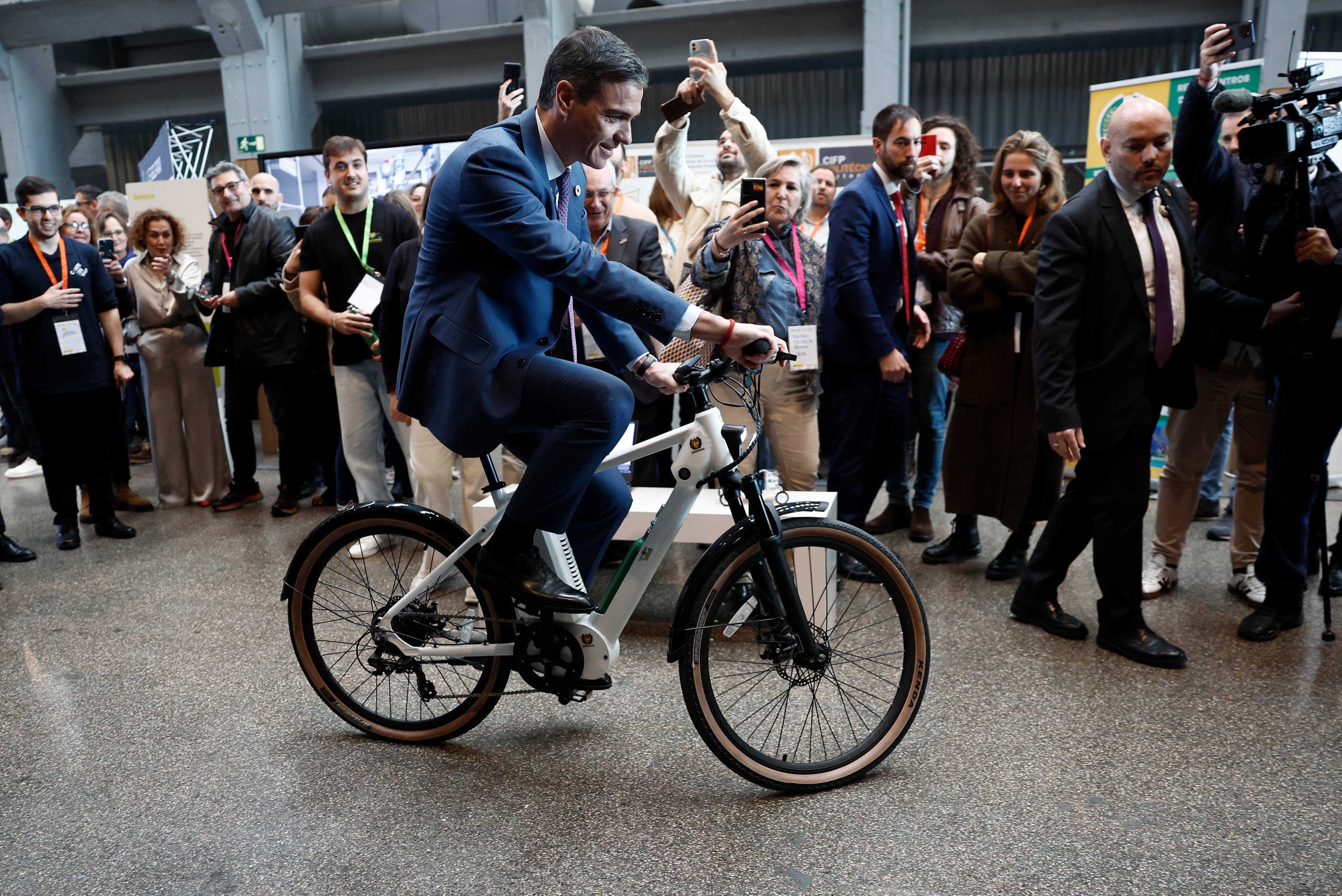 El presidente del Gobierno, Pedro Sánchez, prueba una bicicleta eléctrica propulsada con un motor de hidrógeno verde mientras preside el acto de firma para el lanzamiento de varios hubs de la Alianza para la Formación Profesional en Madrid.