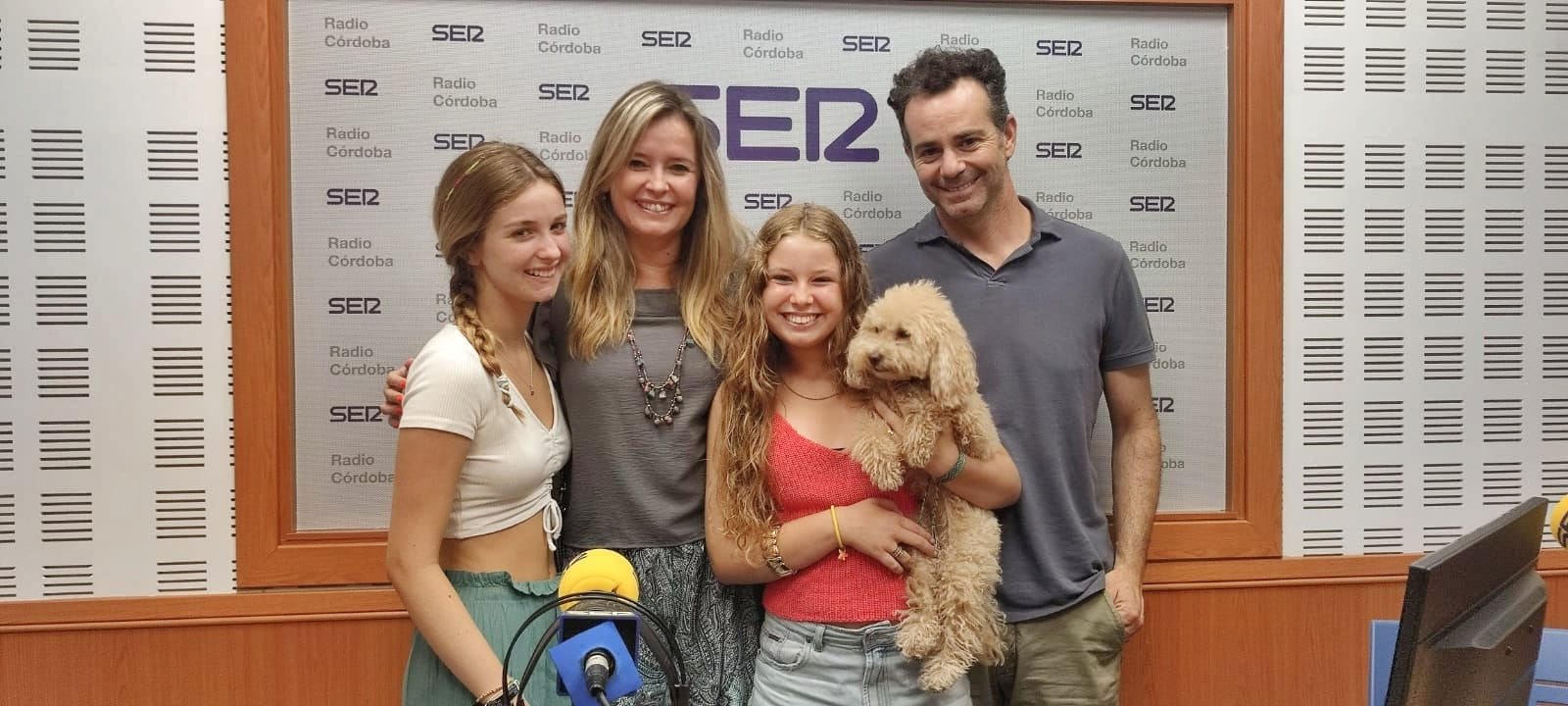 Julia (de rojo y sujetando a su perrita), la niña cordobesa Julia, la niña cordobesa que se ofrece a sacar a pasear gratis a los perros de las personas que no puedan hacerlo, ha venido a la radio con su familia a contarnos su iniciativa