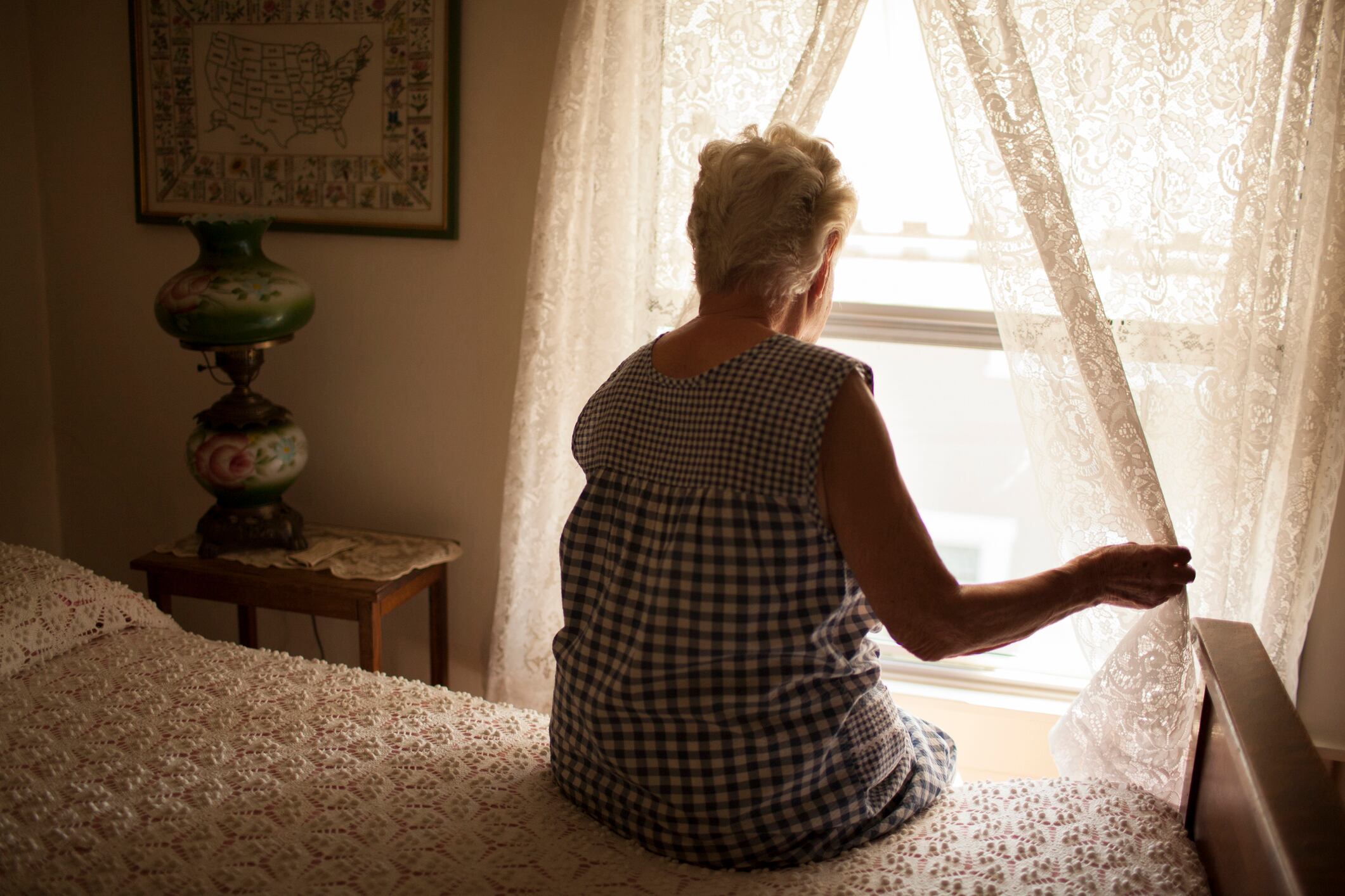 Una anciana mirando por la ventana de su habitación