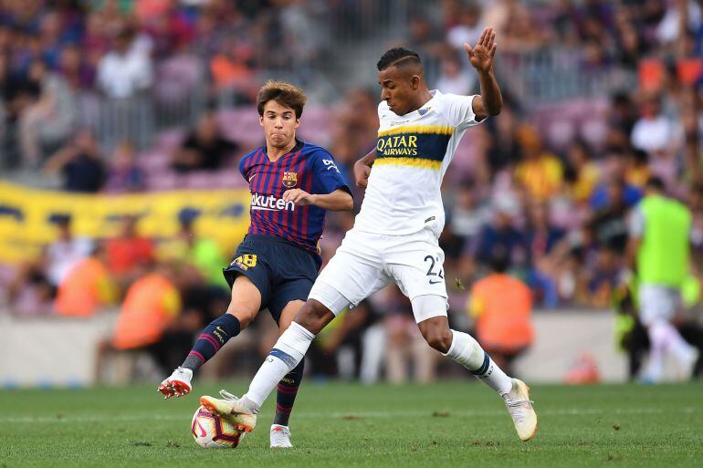 Riqui Puig (Barcelona) y Sebastian Villa (Boca) pelean por un balón durante el encuentro 