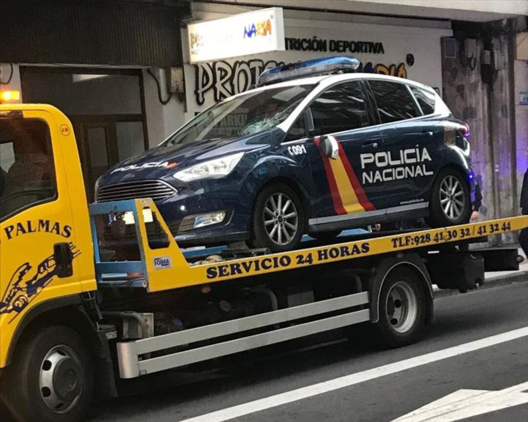 Una grúa retira el coche policial accidentado.