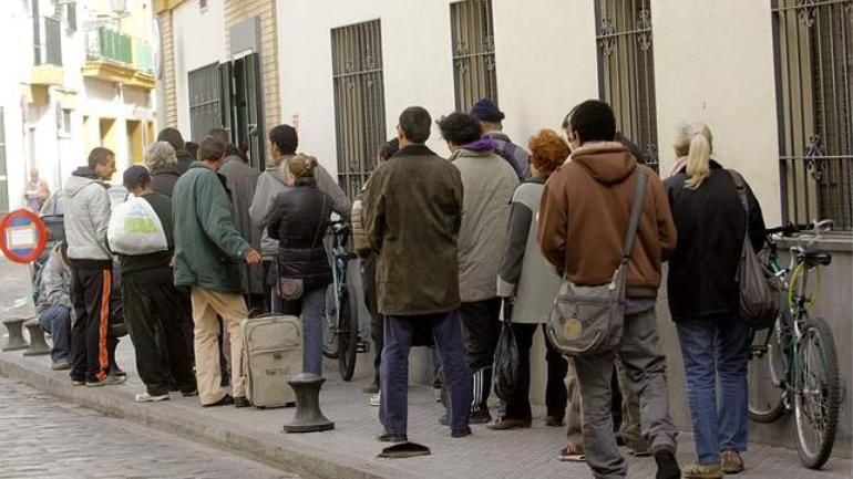 Esta es la estampa que se vive a diario en las puertas del comedor social que las Hijas de la Caridad tienen junto a la Plaza de Pumarejo, en el barrio sevillano de La Macarena