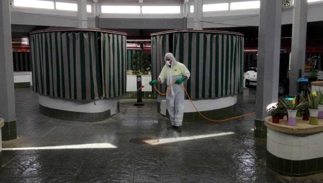 Profesionales desinfectando las instalaciones del mercado de abastos de Andújar.