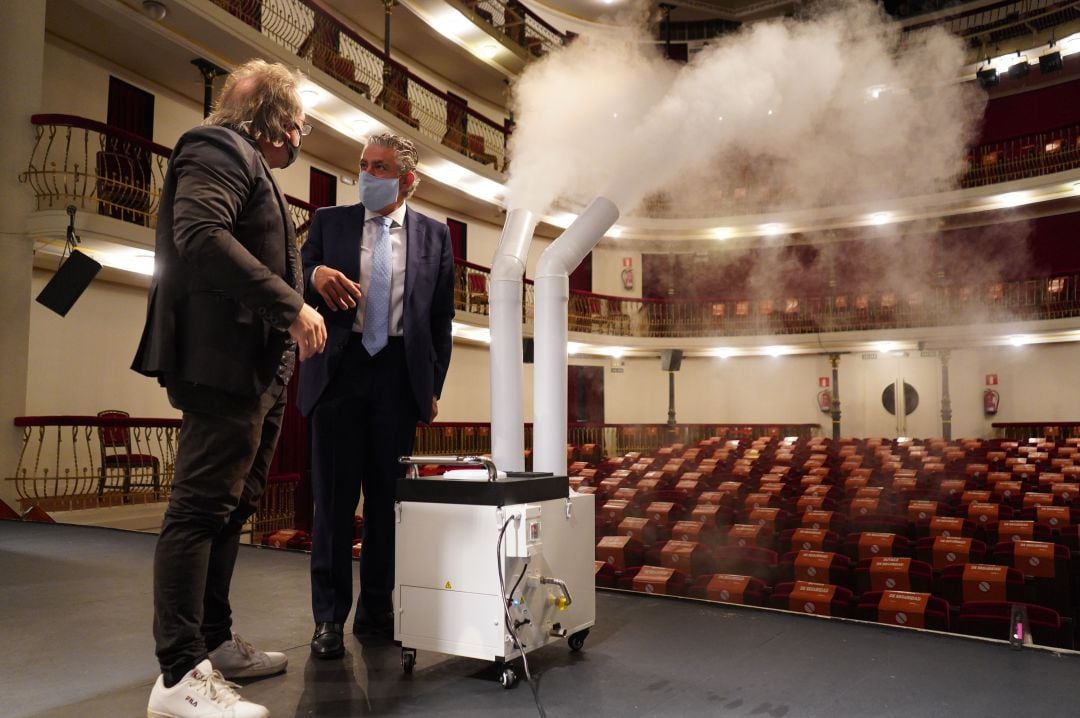 El diputado de Cultura José María Bravo y el director del teatro Marco Costa junto a la máquina de nebulización para la desinfección de la sala 