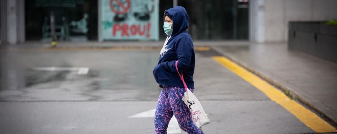 Persona con mascarilla caminando por la calle