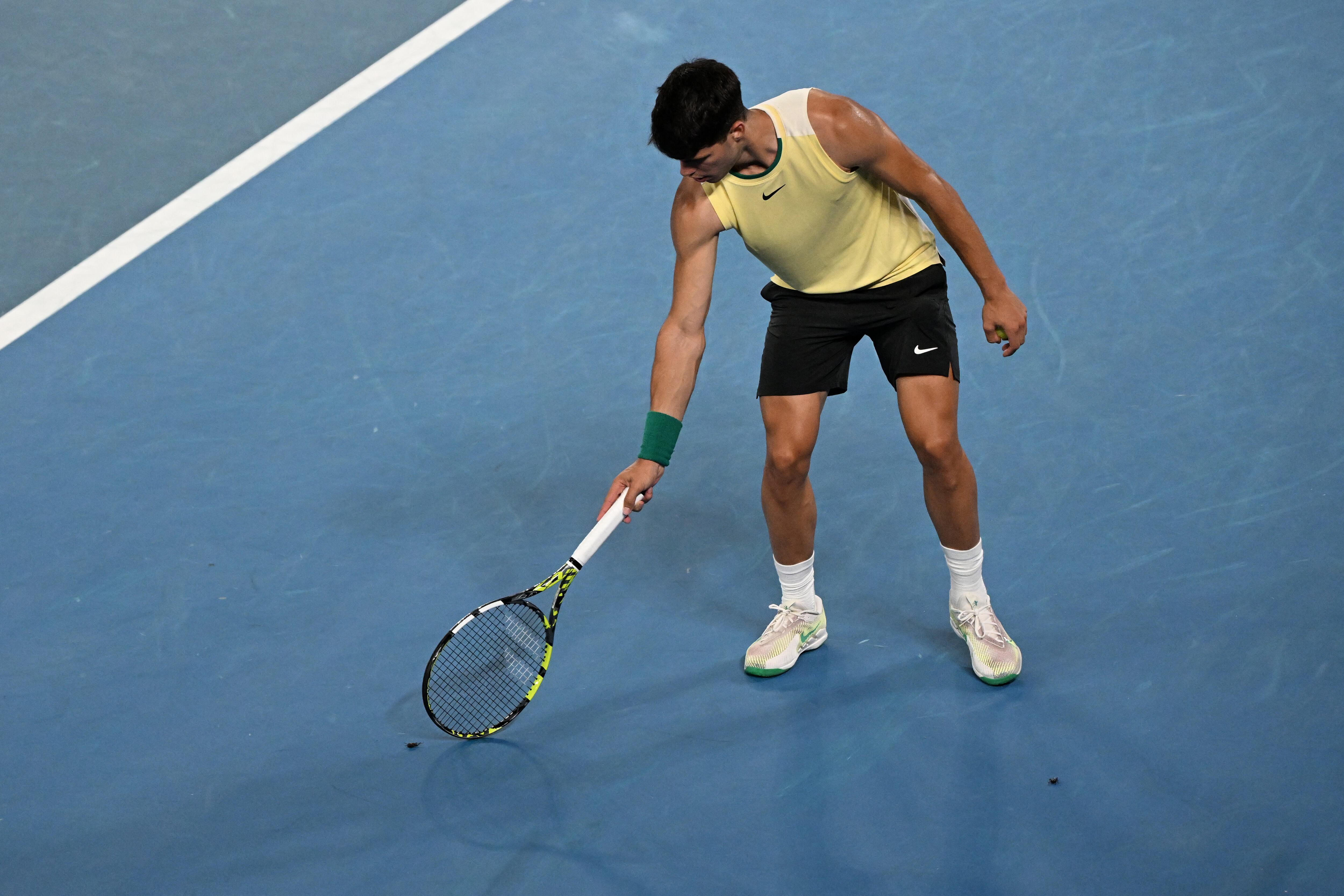 Carlos Alcaraz expulsa a un saltamontes de la pista en su debut en el Open de Australia. (Photo by WILLIAM WEST / AFP)