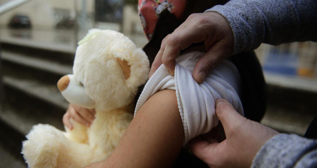 Una niña se prepara para ser vacunada