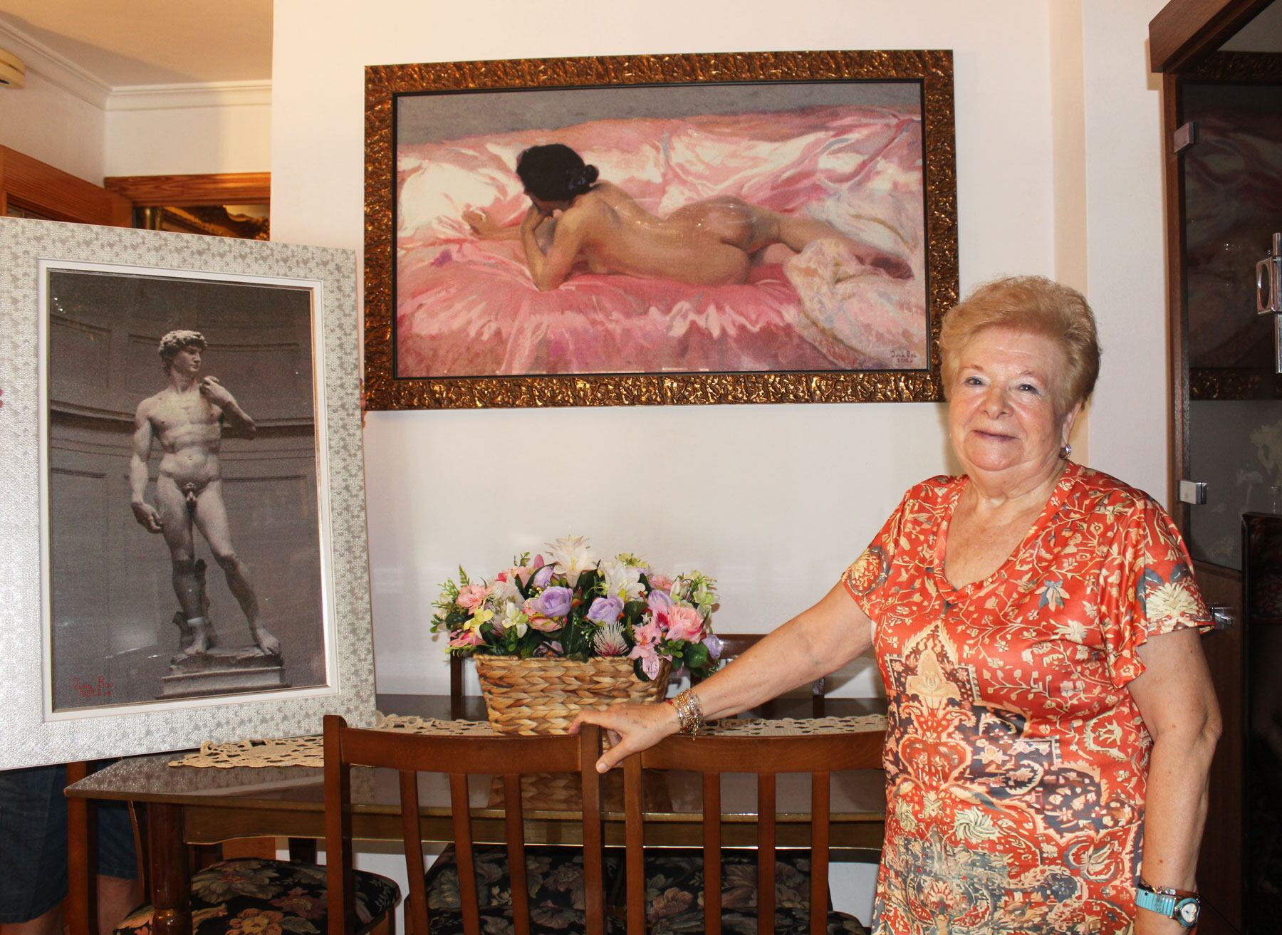 Julia Bou, en el comedor de la seua casa, junt a dos de les seues obres, el David de Miguel Ángel i la dona de Sorolla en un quadre