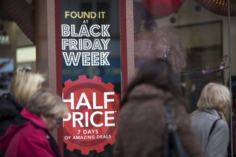 Shoppers walk past a sign for Black Friday deals on a department store on Oxford Street on November 22, 2016 in London, England. British retailers have begun to offer deals on a range of their products as part of the pre-Christmas Black Friday shopping ev