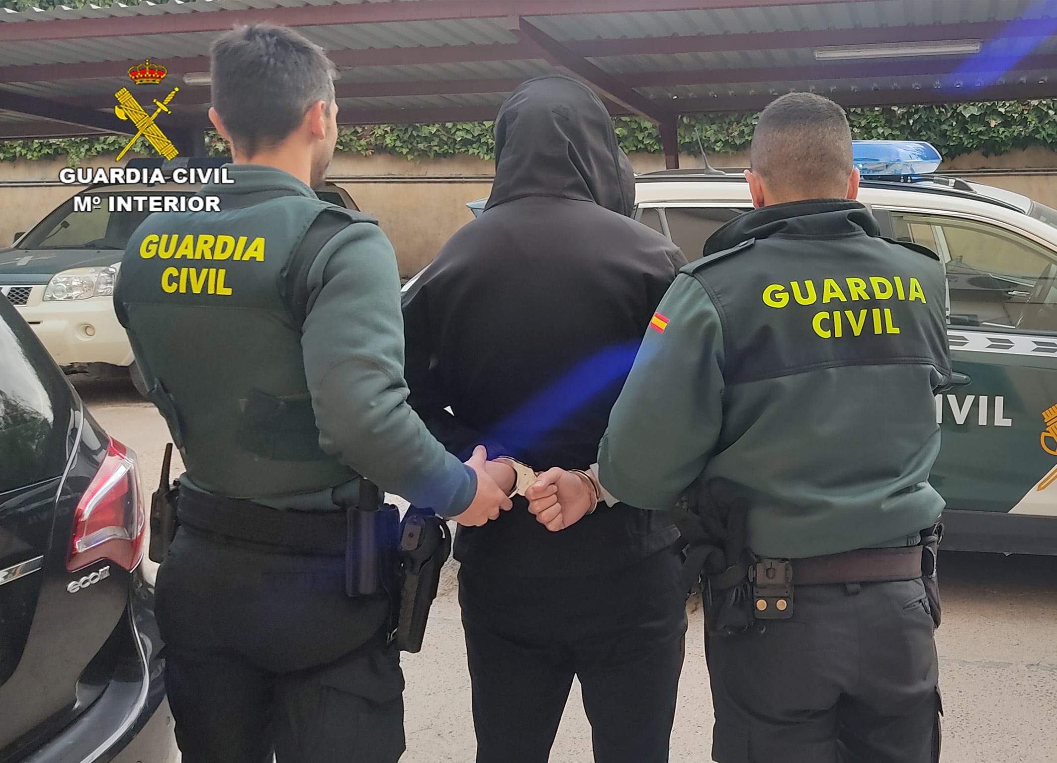 Agentes de la Guardia Civil trasladando a uno de los arrestados