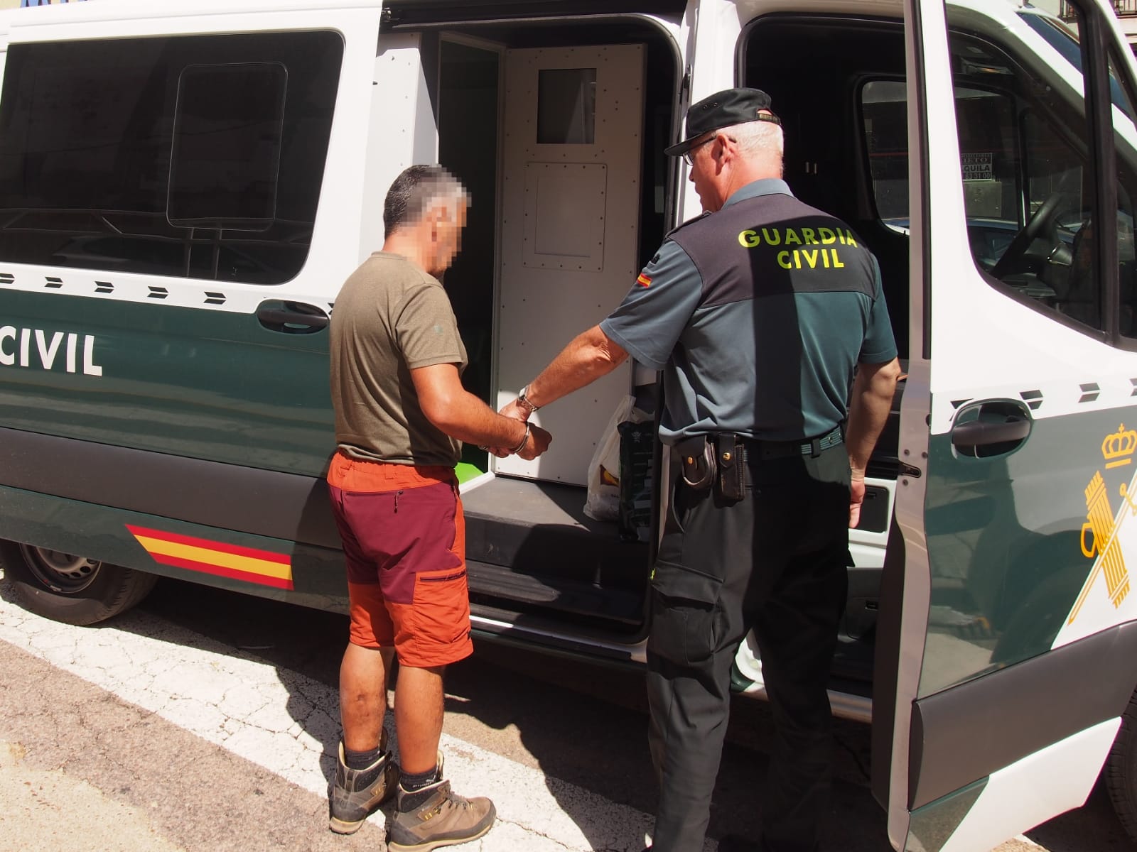 El supuesto autor es conducido al furgón de la Guardia Civil