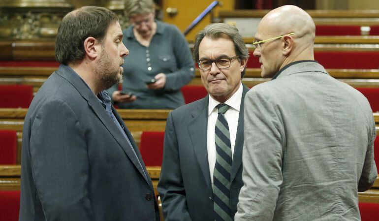 Los diputados de Junts pel Si, Artur Mas (c), Raül Romeva (d) y Oriol Junqueras (i), conversan poco antes de iniciarse la sesión vespertina del pleno del Parlament de Cataluña