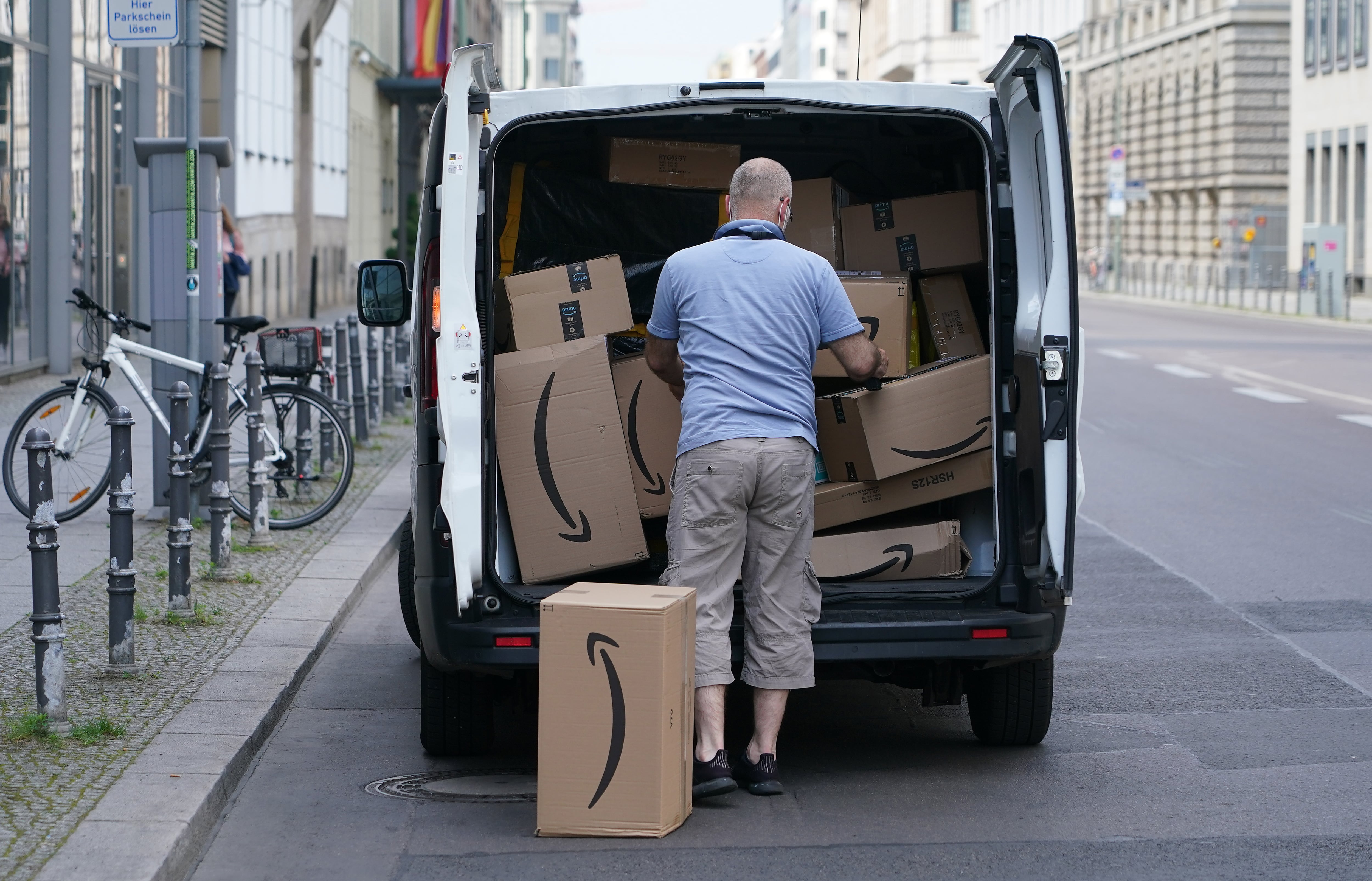 Un repartidor de Amazon con varios paquetes.