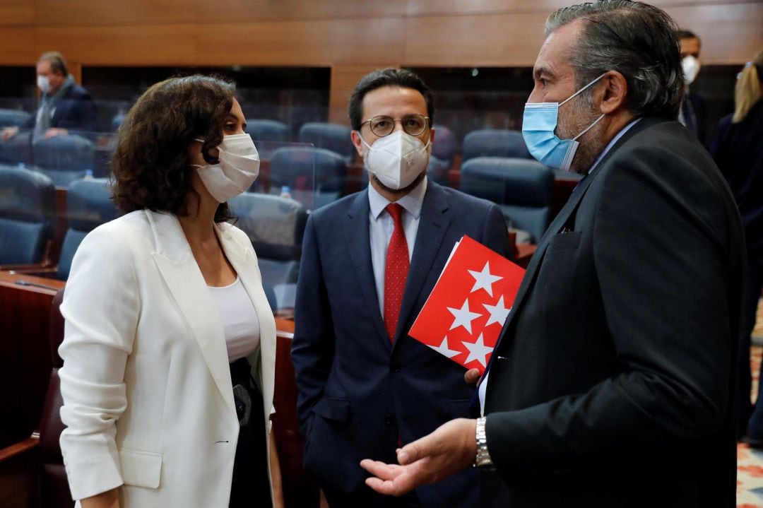 La presidenta regional, Isabel Díaz-Ayuso, conversa con los consejeros de Hacienda y Función Pública Javier Fernández-Lasquetty e Interior, Enrique Lopez, al inicio del pleno de la Asamblea de Madrid.