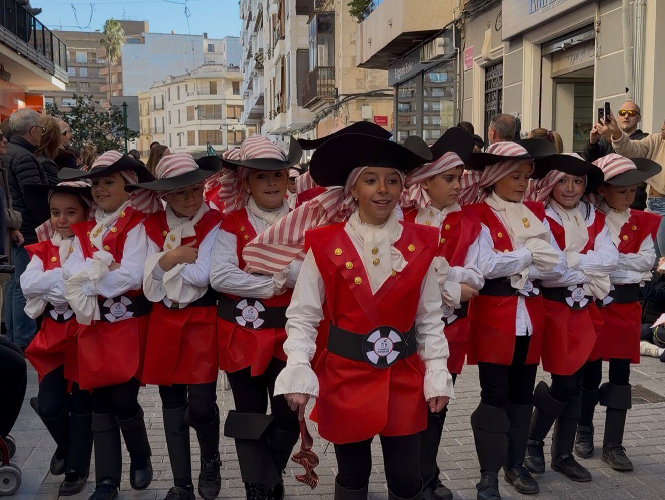 El Carrer Major de Ontinyent se llenó de público durante el desfile escolar del Medio Año Festero, con la participación de los centros educativos y el entusiasmo de los más pequeños como protagonistas.